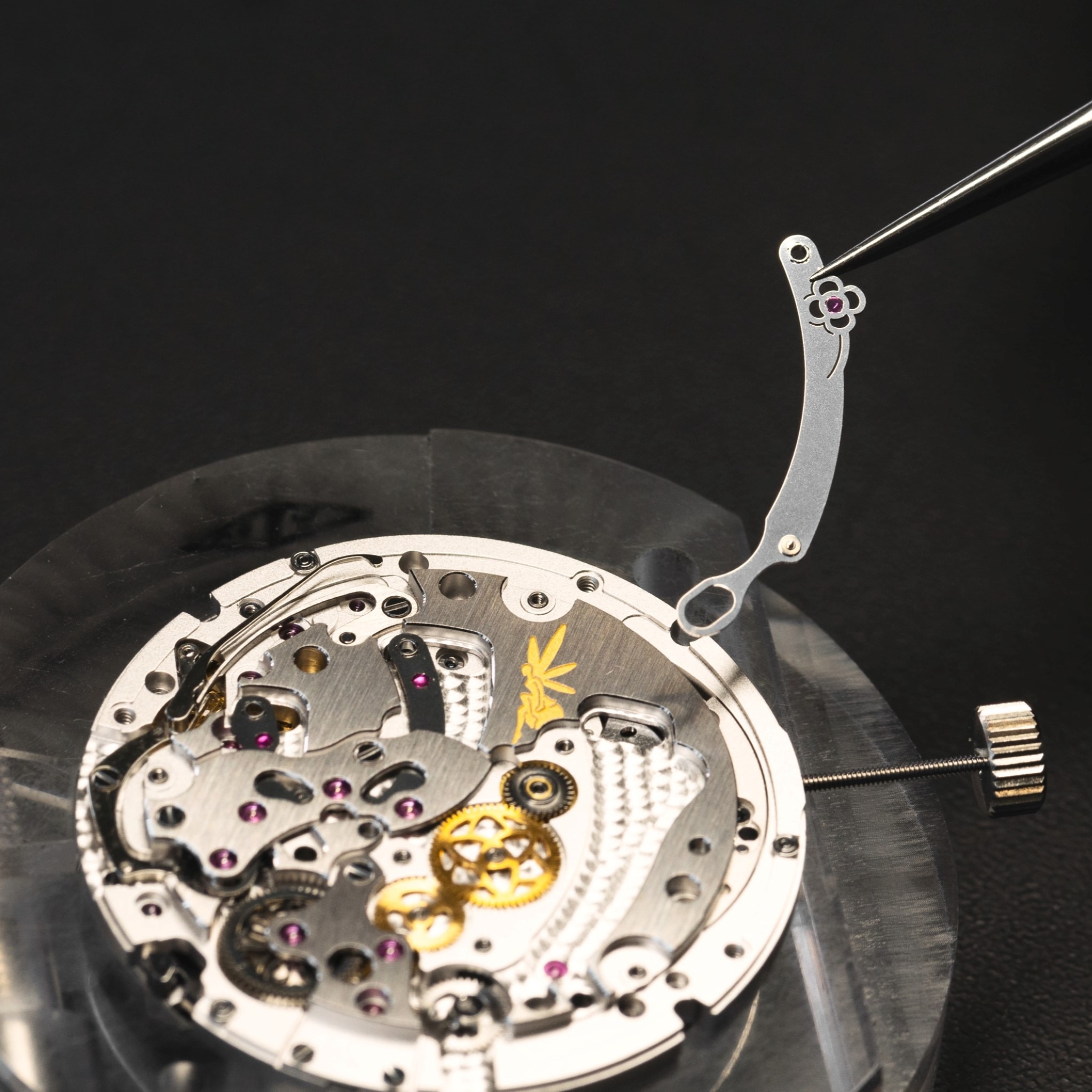 將花朵控制桿放在 Lady Arpels Brise d'Été 腕錶的機芯上,Van Cleef & Arpels 梵克雅寶。